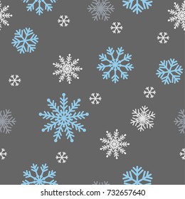 Snowflakes in blue, light gray and white in various shape seamless pattern on dark gray at night background, design for decorated in winter season holiday.