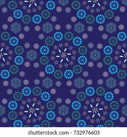 Snowflakes in blue. seamless vector geometric pattern of various shapes of snowflakes arranged in floral structure over a deep blue background.