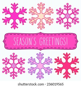 Snowflakes in rows and a frame with hand written season's greetings.