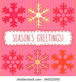 Snowflakes in rows and a frame with hand written season's greetings.