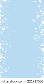 Snowy christmas background. Subtle flying snow flakes and stars on light blue winter backdrop. Delicate sweet snowy christmas. Vertical vector illustration.