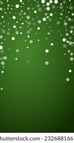 Snowy christmas background. Subtle flying snow flakes and stars on christmas green background. Delicate sweet snowy christmas. Vertical vector illustration.