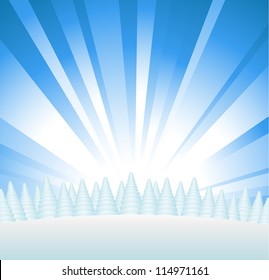 Snowy forest on hill with sunburst