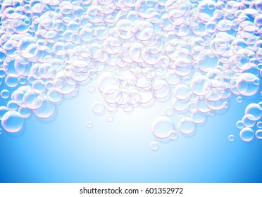 Soap bubbles blue background with rainbow colored airy foam