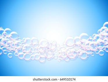 Soap bubbles blue background with rainbow colored airy foam