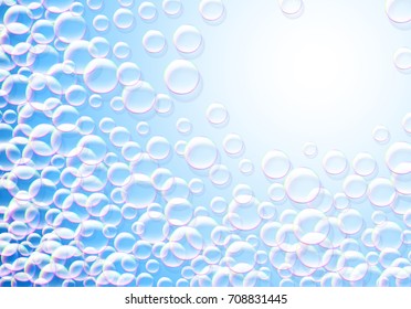 Soap bubbles blue background with rainbow colored airy foam