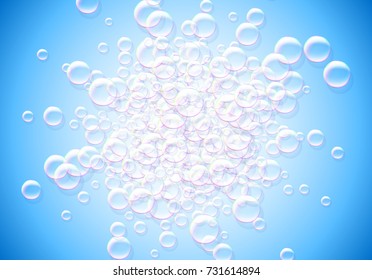 Soap bubbles blue background with rainbow colored airy foam explosion