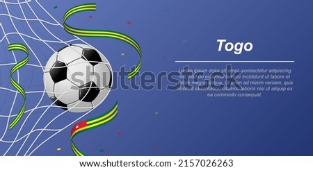 Soccer background with flying ribbons in colors of the flag of Togo. Realistic soccer ball in goal net.