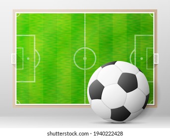 Soccer ball against association football field. Sport equipment and soccer pitch board