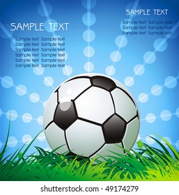 Soccer ball on green grass over a natural clear blue sky background