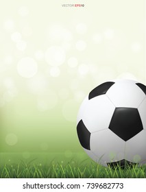 Soccer football ball on green grass field with light blurred bokeh background. Vector illustration.