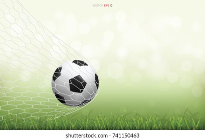 Soccer football ball on green grass field with light blurred bokeh background. Vector illustration.