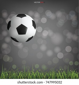 Soccer football ball on green grass field with light blurred bokeh background. Vector illustration.