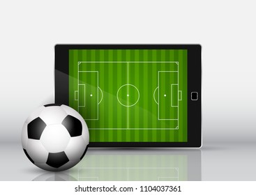 Soccer or football in front of an electronic device with pitch on screen