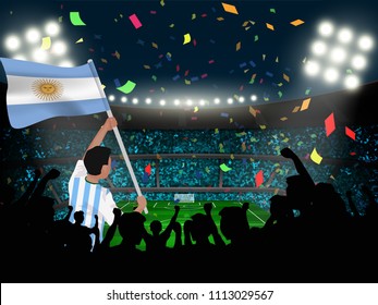 Un hincha del fútbol sostiene la bandera argentina entre la silueta de público en un estadio para celebrar o celebrar un partido de fútbol.