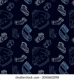 Socks, mittens, scarf, sweater. Seamless pattern on a dark blue background. Cute winter print.