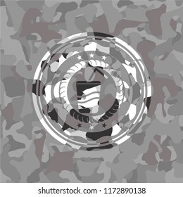 soda icon inside grey camouflage emblem