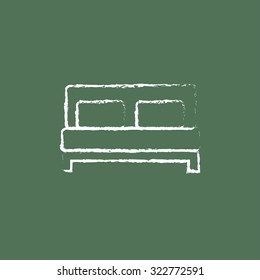 Sofa hand drawn in chalk on a blackboard vector white icon isolated on a green background.