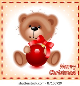 soft teddy toy bear with a Christmas ball on the background of the sewing texture