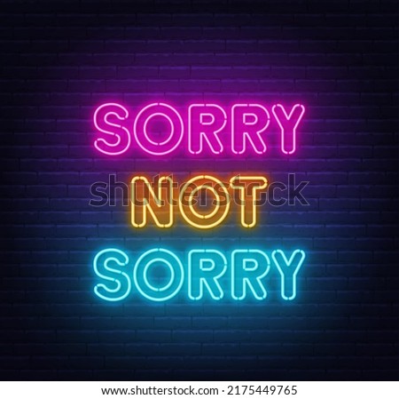 Sorry Not Sorry neon lettering on brick wall background.
