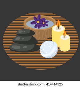 Spa procedure accessories on makisu mat. Spa massage pebbles, candles, bath bomb and aroma water in bowl.
