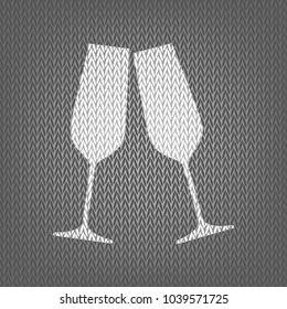 Sparkling champagne glasses. Vector. White knitted icon on gray knitted background. Isolated.