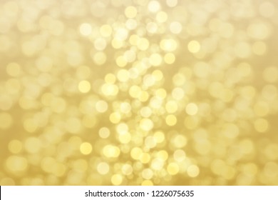 Sparkling golden glittering effect. Glowing yellow lights background