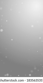 Sparse snowfall Christmas background. Subtle flying snow flakes and stars on grey background. Actual winter silver snowflake overlay template. Comely vertical illustration.