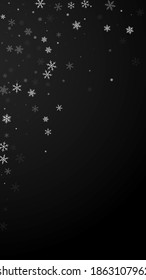 Sparse snowfall Christmas background. Subtle flying snow flakes and stars on black background. Alive winter silver snowflake overlay template. Neat vertical illustration.