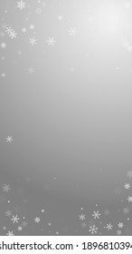 Sparse snowfall Christmas background. Subtle flying snow flakes and stars on grey background. Alluring winter silver snowflake overlay template. Powerful vertical illustration.