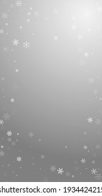 Sparse snowfall Christmas background. Subtle flying snow flakes and stars on grey background. Actual winter silver snowflake overlay template. Memorable vertical illustration.