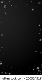 Sparse snowfall Christmas background. Subtle flying snow flakes and stars on black background. Actual winter silver snowflake overlay template. Resplendent vertical illustration.