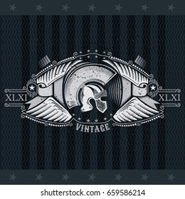 Spartan helmet side view between wings and ribbons. Heraldic vintage label on blackboard