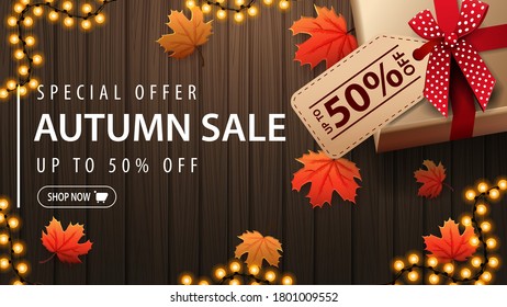 Special offer, autumn sale, up to 50% off, brown discount banner with gift box, autumn leafs and wooden background, top view