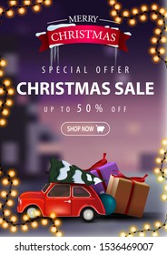 Special offer, Christmas sale, up to 50% off, beautiful discount banner with garland and red vintage car carrying Christmas tree. Vertical discount banner with blurred winter landscape on the backgrou