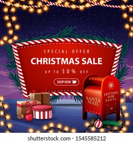 Special offer, Christmas sale, up to 50% off, red discount banner with Christmas tree branches, garland, winter landscape on the background and Santa letterbox with presents