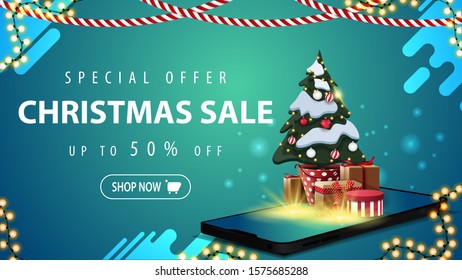 Special offer, Christmas sale, up to 50% off, blue discount banner for website with garlands, button and smartphone from the screen which appear Christmas tree in a pot with gifts