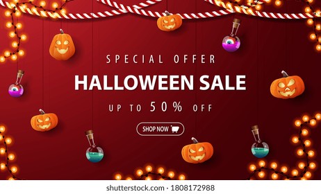 Special offer, Halloween sale, red discount banner with pumpkins Jacks and flask of potion tied with ropes hanging near the wall