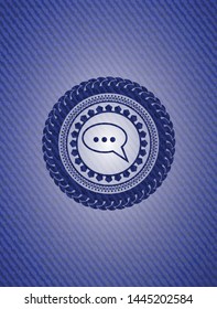 speech bubble icon inside emblem with denim texture