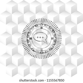 speech bubble icon inside grey emblem with cube white background
