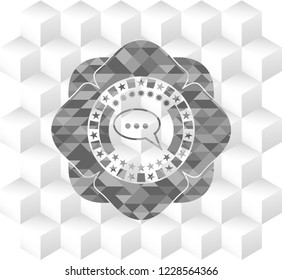 speech bubble icon inside grey badge with geometric cube white background