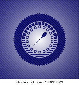 sperm icon inside badge with denim background