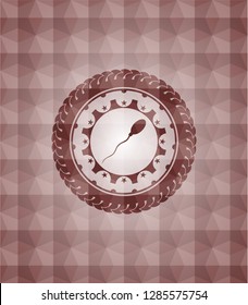 sperm icon inside red seamless emblem or badge with geometric pattern background.