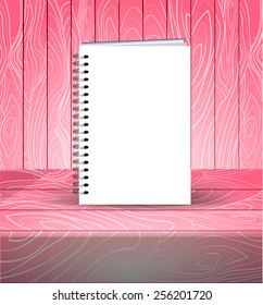 Spiral bound notepad. Vector template. Easy to place your image on the cover. Pink wooden background.