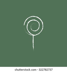 Spiral lollipop hand drawn in chalk on a blackboard vector white icon isolated on a green background.