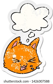 spitting cartoon cat face with thought bubble as a distressed worn sticker