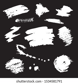 Splashes of white paint on a black background. Paint brush strokes collection