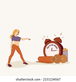 Sport young woman wearing casual workout clothes. Training and home exercising and fitness equipment. Dumbbell, yoga mat and bottle. Girl pointing at the alarm clock with time to lose weight text