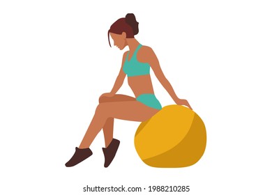 Sporting slim young woman in green suit sits on a yellow ball for fitness