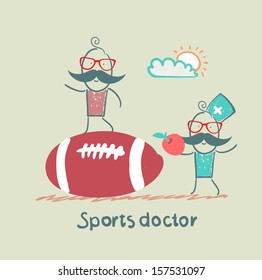 Sports doctor giving an apple to the person who sits on a huge soccer ball